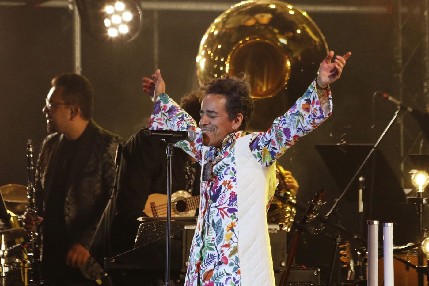 Rubén Albarrán von Café Tacvba singt mit erhobenen Armen, hinter ihm ein Sousafon